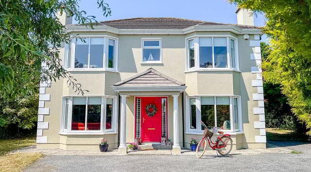 Front exterior of 16 Maiden Hill with bay windows and red front door