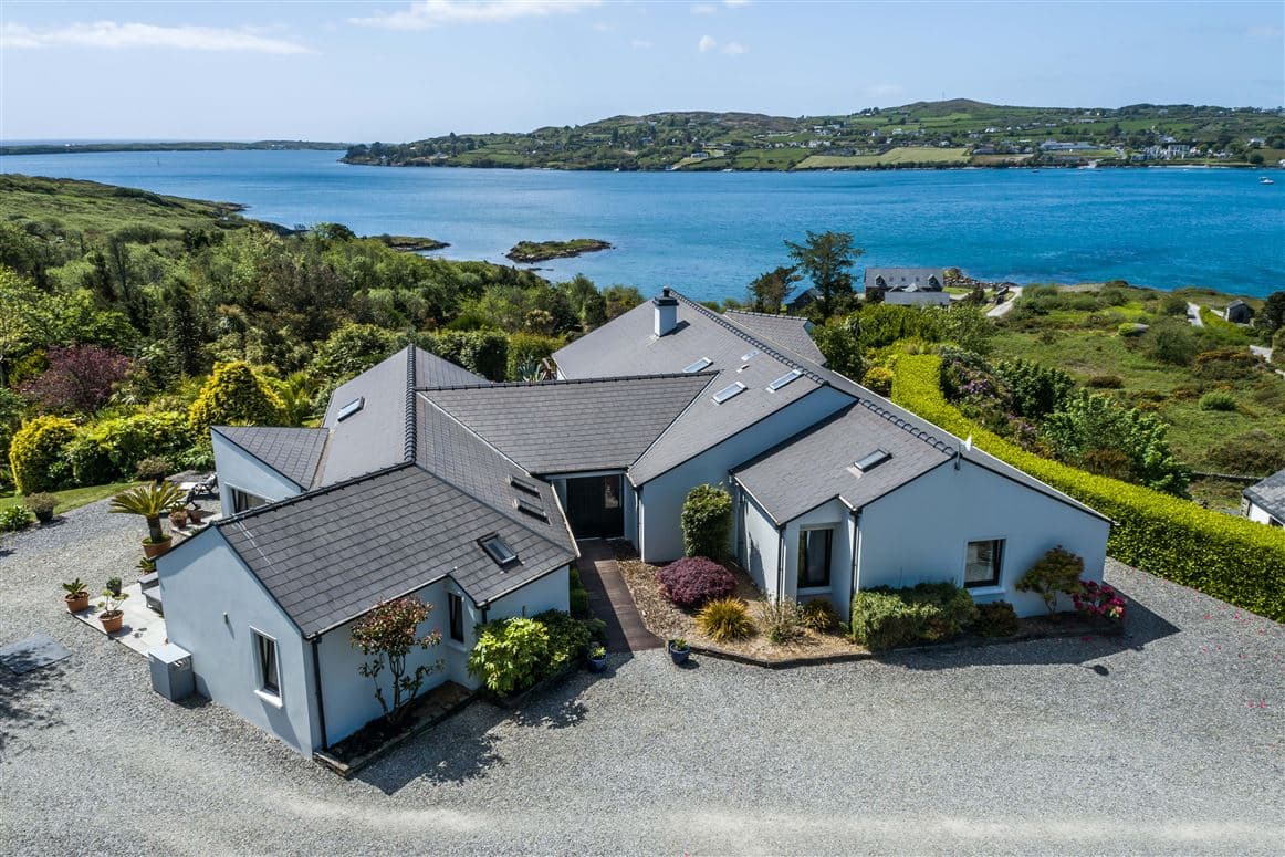 Aerial view of the house and gravel driveway with the harbour beyond