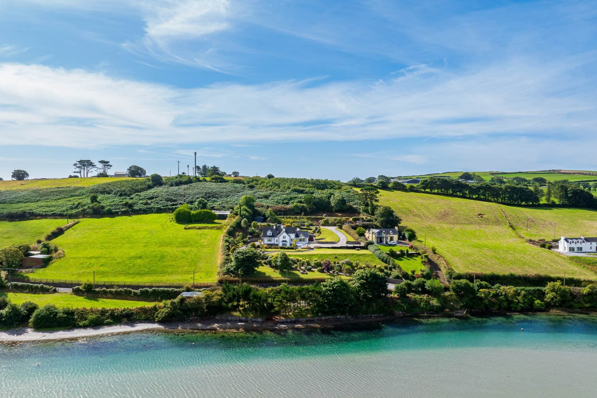 Aerial view of the landscaped grounds and coastline surrounding the property