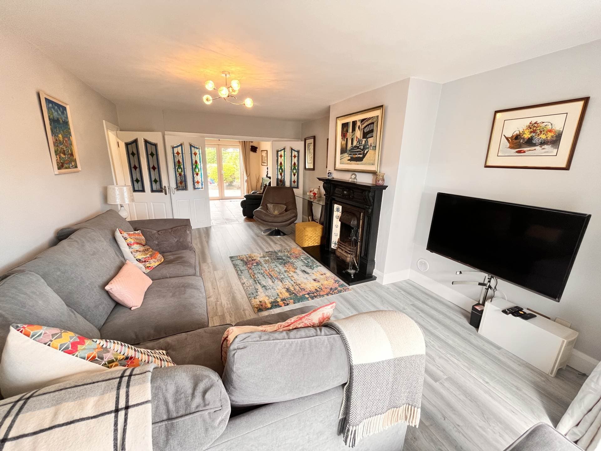 Second reception room with fireplace and stained-glass doors leading to the garden