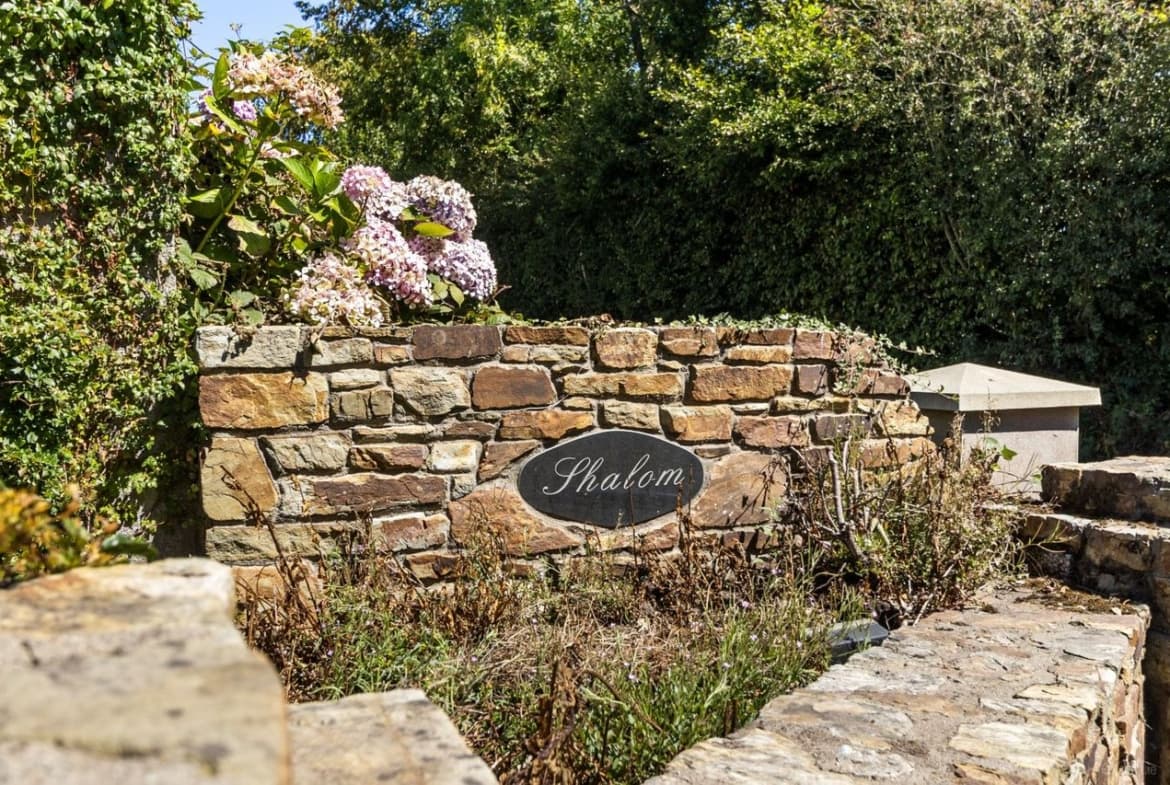 Stone entrance wall and mature gardens at Young Grove